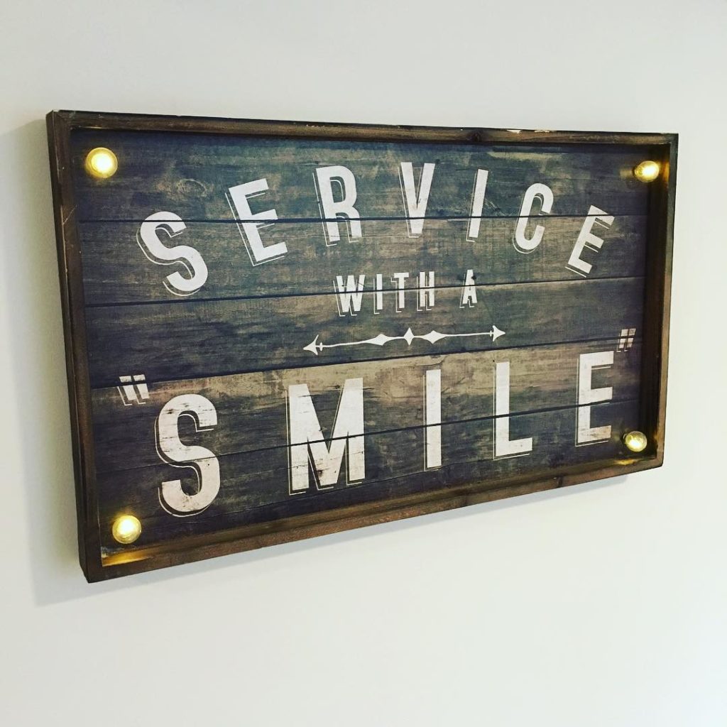 sign which reads 'service with a smile'